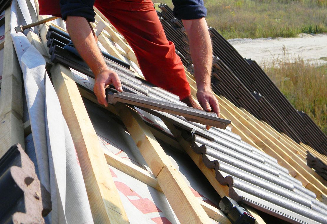 A roofer installing a tiled roof